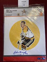 John Bucyk NHL All-Stars lithograph in protective plastic sleeve showing the artwork and signature reproductions, limited edition number 6 of 6.