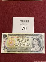 Front of Canadian one dollar bill showing Queen Elizabeth II and serial number AM0096988