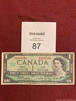 Front view of the Canadian one dollar bill showing Queen Elizabeth II and serial number 8807150.