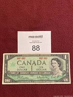 Front of 1967 Canadian one dollar bill with portrait of Queen Elizabeth II and centennial markings.