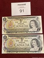Front side of two sequential Canadian one dollar bills showing Queen Elizabeth II and serial numbers AD9183707 and AD9183706