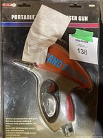 Portable sand blaster gun in original packaging with instruction sheet inside.
