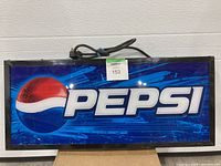 Rectangular illuminated Pepsi sign with the brand's logo and name, showing dents and some wear.