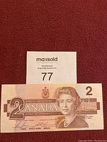 Front view of Canadian two dollar bill showing Queen Elizabeth II portrait and denomination