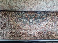 Rolled and flat views of the Persian style rug showing pattern and border details.