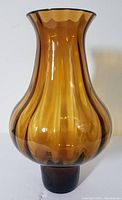 Front view of amber glass vase showing reverse ribbed design and flared rim.