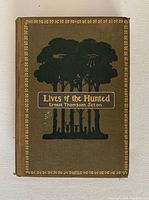 Front cover of the book showing title "Lives of the Hunted" and author Ernest Thompson Seton, with embossed tree illustration and gold detailing.