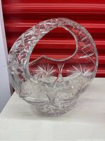 Front view of the heavy cut crystal basket showing embossed ornate diamond and starburst cut patterns with a curved handle.