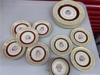 Photo showing full set of plates and soup bowl arranged on a table with visible floral and gold accent designs