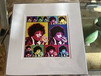 Framed multi-color pop art print of Jimi Hendrix with grid layout of 10 images, showing vibrant colors and white matte board.