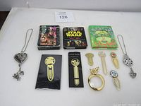 Complete lot showing miniature Star Wars books, playing cards, garden pop-up book, metal bookmarks and apple shaped magnifier
