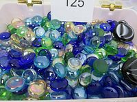 Mixed color glass pebbles and marbles in blue, green, aqua, clear with iridescence, and black close-up.