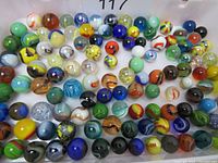 Overview of the lot of 115 assorted glass marbles showing multiple colors and patterns