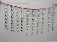 Full view of 10 vintage clear glass crystal chandelier strings displayed hanging, showing variation in length and crystal sizes.