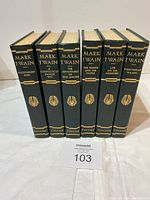 Six hardcover Mark Twain books standing side by side showing gold embossed titles on spine.