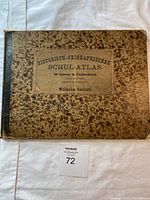 Cover of the atlas showing mottled brown binding and title 'Historisch-Geographischer Schul-Atlas' with 36 maps noted, authored by Wilhelm Issleib