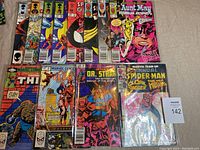 12 Marvel comic books displayed on a surface, showing front covers. Includes Spider-Man Team Up, What If, Two In One, Thor, Doctor Strange covers among others. Comics are bagged in plastic.