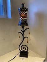 Lamp fully visible, showing stained glass shade and swirl metal stem base with cord.