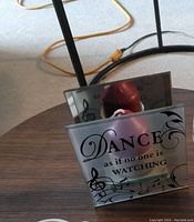 Two frosted glass tea light holders, one with music notes and the phrase 'Dance as if no one is watching' with a red tea light candle inside