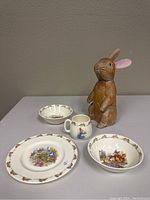 Photo showing all four dishes and the wooden bunny figure arranged on a table.