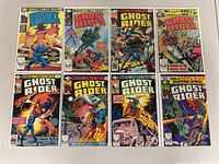 10 Ghost Rider comic books laid out on a surface, showing front covers featuring the character Ghost Rider in various action scenes with motorcycles and supernatural elements.