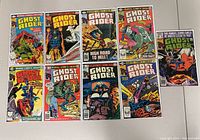 Top-down photo showing all 9 Ghost Rider comic books laid out in 3 rows of 3, featuring colorful vintage Marvel covers with Ghost Rider artwork.