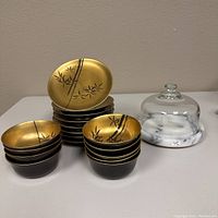 Set of lacquer rice bowls and plates, black exterior with gold bamboo design interior, paired with a glass covered marble tray.
