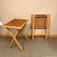 Two folding wood TV trays, one set up, one folded, showing overall condition and construction