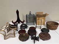 Wide shot showing all items including wooden plate stands, wire bird cage decoration, metal stand, star-shaped wire basket, and several round wooden plate stands.