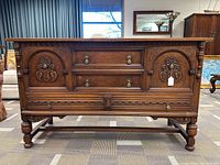 Full front view of oak sideboard showing overall design, carvings, legs and base