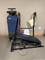 Full view of inversion table and Total Gym Platinum rowing machine bench against wall