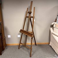 Front view of the vintage wooden easel showing adjustable support mechanisms and tripod style legs