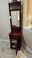 Full height view of wooden hall cabinet with mirror, drawer, lower cabinet and hooks