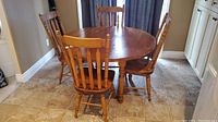 Round solid pine dining table with four matching chairs, showing front view and condition of tabletop.