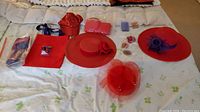 Overview of hats, bags, and jewelry laid out on bed showing the full assortment in the lot