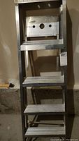 Close-up of 3 steps framing showing wide, textured treads and part of the ladder frame.