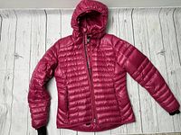Pink Adidas puffy insulated jacket laid flat showing front with hood and zipper.