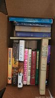 Top view of box showing varied hardcover books including Life of Pi, Inferno, Folk Songs, and others.
