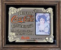 Front view of Coca-Cola advertising mirror showing vintage artwork and text.