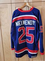 Full back view of jersey hanging on hangers, showing overall condition and tags attached.