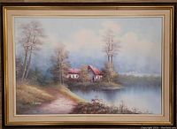 Full view of large framed oil painting showing the lakeside scene with buildings, trees, and path.
