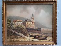 Full view of framed oil painting showing seaside scene with buildings, boats, and carved gold-tone frame