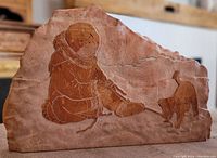 Front view showing the entire red marble carving of a child and puppy with sandblasted detail.