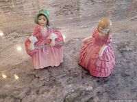 Front view of Bo Peep and Rose figurines on marble surface, showing detailed dresses and facial features.
