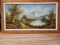 Full view of landscape oil painting with wooden frame.