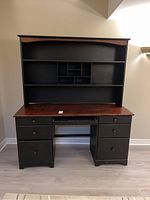 Full view of the desk with hutch showing drawers, pull-out keyboard shelf, and wood finish