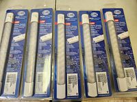 Five Hella Marine LED lamps in original packaging, neatly arranged in a row to show quantity and consistent packaging.