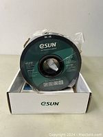 Front view of the filament spool in its packaging showing the eSUN logo and product name.