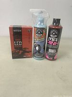 Full lot showing the boxed Wattstar LED headlight sealed, Chemical Guys tire shine spray, and Chemical Guys Mr Pink shampoo bottle