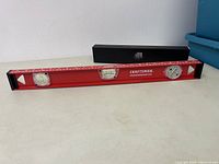 Full view of Craftsman 24-inch level accompanied by black sleeved power supply cable in box.